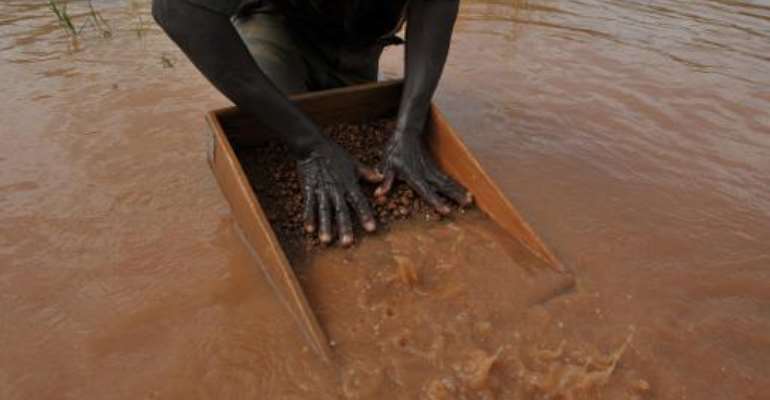 A man sifts through pebbles searching for diamonds in the village of Bobi, north western Ivory Coast, on November 18, 2009. By Issouf Sanogo (AFP/File)