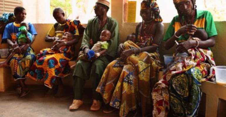 Parents feed their malnourished children with enriched milk on March 21, at a hospital run by a French NGO. By Raphael de Bengy (AFP/File)