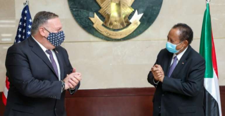 US Secretary of State Mike Pompeo (L) visited Prime Minister Abdalla Hamdok (R) of Sudan in August as the legislation was being prepared. By Handout (Office of Sudan's Prime Minister/AFP/File)