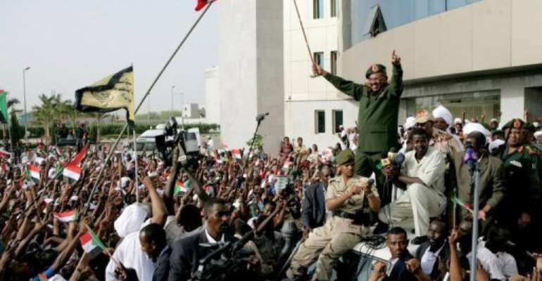 Sudanese President Omar al-Bashir waves to the crowd gathering outside the Defence Ministry in Khartoum. By Ashraf Shazly (AFP)