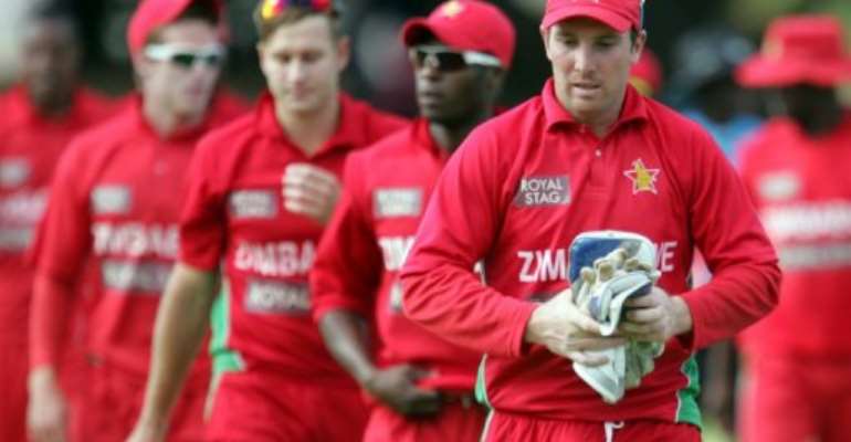 Zimbabwe's Brendan Taylor leaves the field with teammates after loosing to India, in Harare, on August 3, 2013. By Jekesai Njikizana (AFP/File)