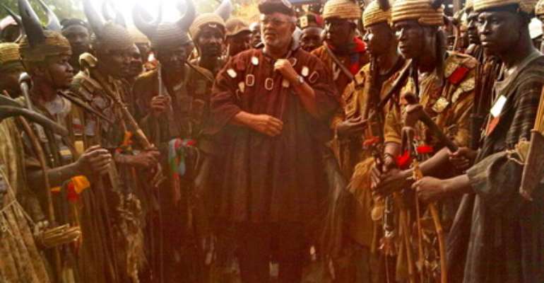 Ex-President Rawlings in traditional battle garb as he poses with the warriors