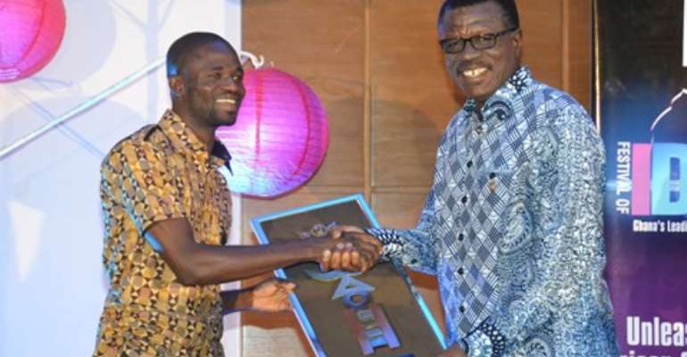 Manesseh Azure Awuni (left) being presented with an award by Dr. Mensa Otabil