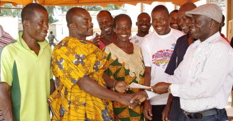Hon. Kuntu Blankson, (right) presenting the cheque to Nana Kweku Badu, Ag regent of the village and his people.