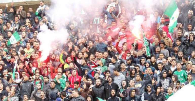 Supporters wave flags during the friendly football game between Ghana's Hearts of Oak SC and Libya's Al-Ahli on December 15, 2015 at the International Stadium in the capital Tripoli