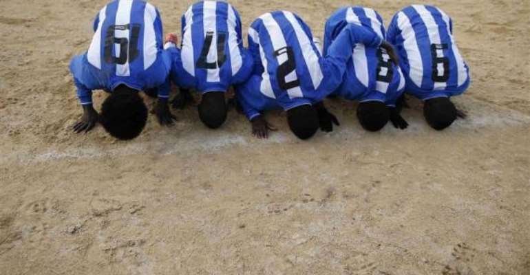 African migrants, who are members of the ASD Mineo soccer team, celebrate after scoring against Massiminiana in the Sicilian village of Mineo January 26, 2014. REUTERS/Tony Gentile