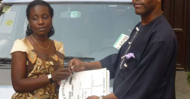 The Prince handing over the key and particulars of the bus to Mary, president of the Ijaw Female Students Association