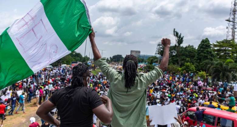 A youth is seen waving the Nigerian flag during protests against police brutality in Lagos on October 13, 2020. CPJ called for journalists' safety to be protected amid the protests. AFPBenson Ibeabuchi