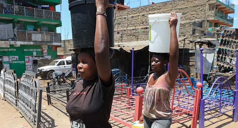 Women carry water buckets filled with water after fetching it from one of the illegal freshwater points in Mathare slum. - Source: EPA-EFEDaniel Irungu