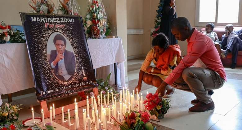 Mourners place candles in front of a portrait of murdered Cameroonian journalist Martinez Zogo, at his outlet Radio Amplitude FM, in Yaound, on January 23, 2023. AFPDaniel Beloumou Olomo