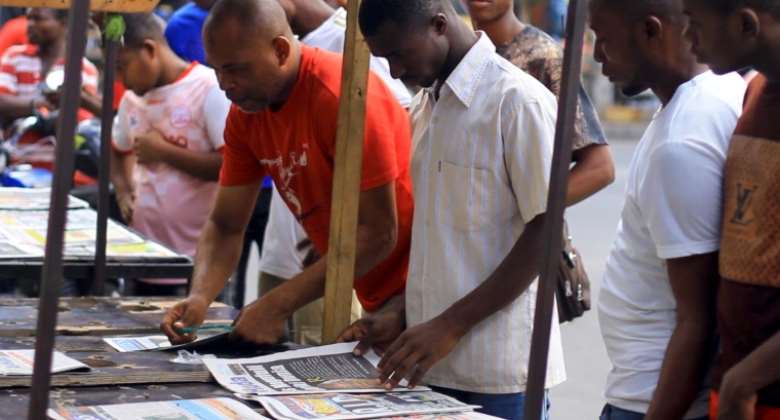 People read newspapers on display in Dar es Salaam, Tanzania on March 18, 2021. Reuters