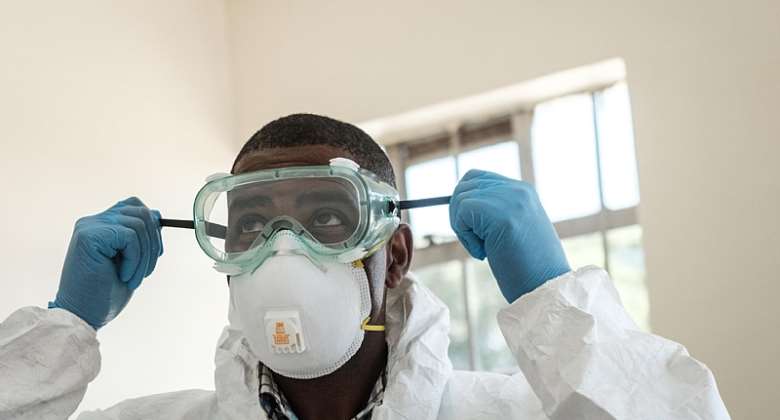 A specialist healthcare worker prepares his PPE before visiting an isolation ward for people who had close contact with the first Kenyan Covid-19 patient at Kenyatta National Hospital in Nairobi, Kenya on 15 March 2020.  AFP