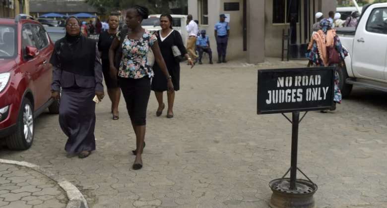 People walk at the premises of Lagos State High Court on January 29, 2019. On June 21, 2022, a federal high court in Ogun state granted bail with strict conditions to Nigerian publisher Olamilekan Hammed Adewale Bashiru. AFPPius Utomi Ekpei