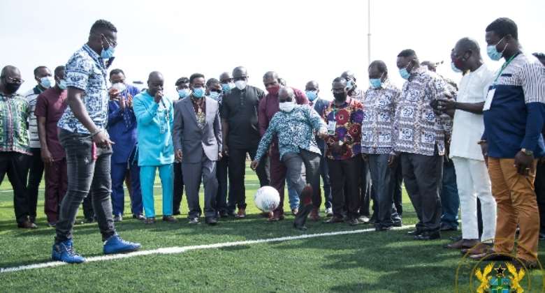 President Akufo-Addo kicks a football as he commissions the AstroTurf facility at UPSA
