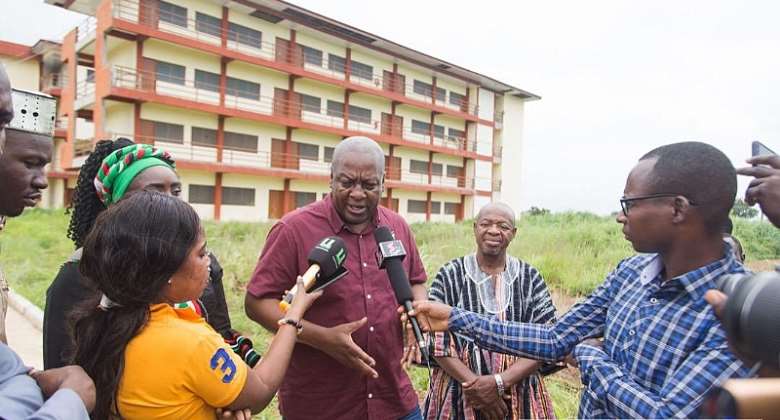 Former President Mahama talking to the media in front of one of the numerous abandoned projects in the new regions.