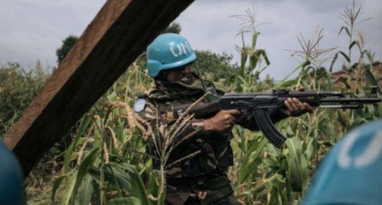 A Bangladeshi soldier with the UN's MONUSCO peacekeeping mission provides covering fire after CODECO militiamen attack a Red Cross party.  By ALEXIS HUGUET AFP