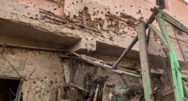 A bullet- and shrapnel-riddled wall in south Khartoum's Souk Sitta.  By - AFP