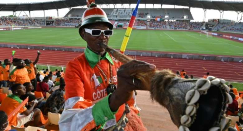 A fan blows a horn before the 2023 Africa Cup of Nations qualifier between the Ivory Coast and Zambia  in Yamoussoukro on June 3, 2022..  By Issouf SANOGO AFP
