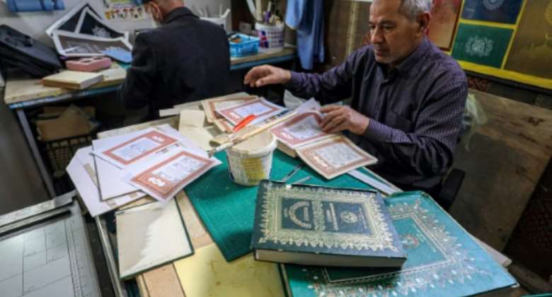 A man assembles pages together to be glued into a volume at a workshop for restoring copies of the Holy Koran, Islam's holy book -- an increasingly popular practice as the price of new Korans goes up in Libya.  By Mahmud Turkia AFP