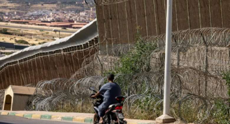 A man rides a motorbike along the border fence separating Morocco and Spain's North African enclave of Melilla.  By FADEL SENNA AFPFile