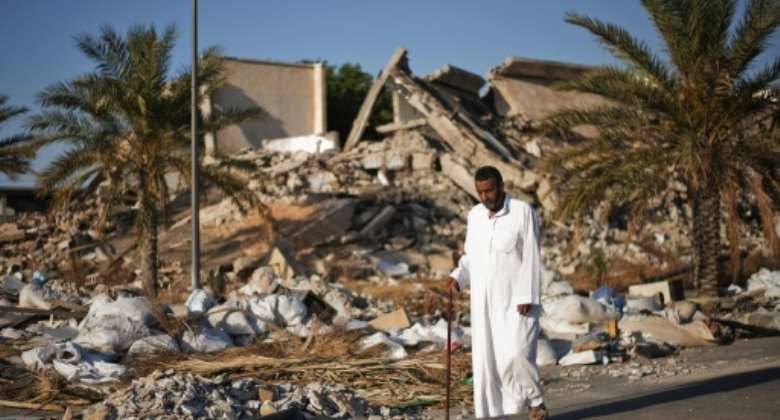 A man walks past a destroyed building at Libyan dictator Moamer Kadhafi's former headquarters in Tripoli in a picture taken in 2012, one year after the ruler was ousted and killed in a NATO-backed uprising.  By GIANLUIGI GUERCIA AFPFile