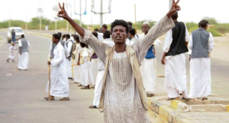 A protester flashes victory signs following the arrival in Port Sudan of a delegation led by a member of Sudan's ruling Sovereign Council on September 26, 2021.  By Ibrahim ISHAQ AFP