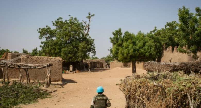 A Senegalese UN peacekeeper walks through the Malian village of Ogossagou where his commanders say there is a lull following two massacres.  By AMAURY HAUCHARD (AFP)