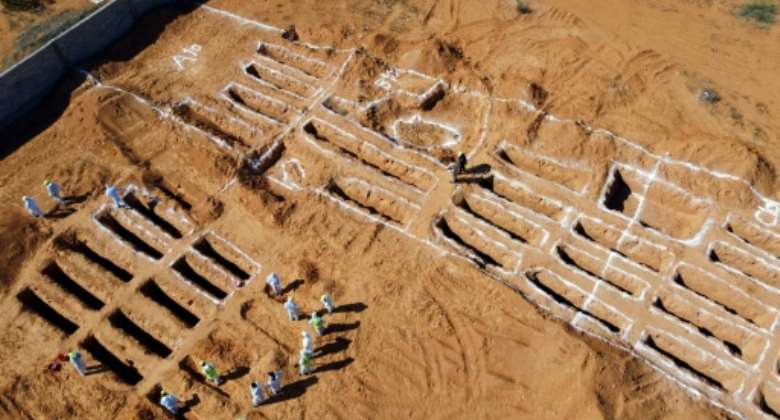 An aerial view shows Libyan experts exhuming human remains from mass graves in Tarhuna, southeast of the capital Tripoli, on October 28, 2020.  By Mahmud TURKIA AFP