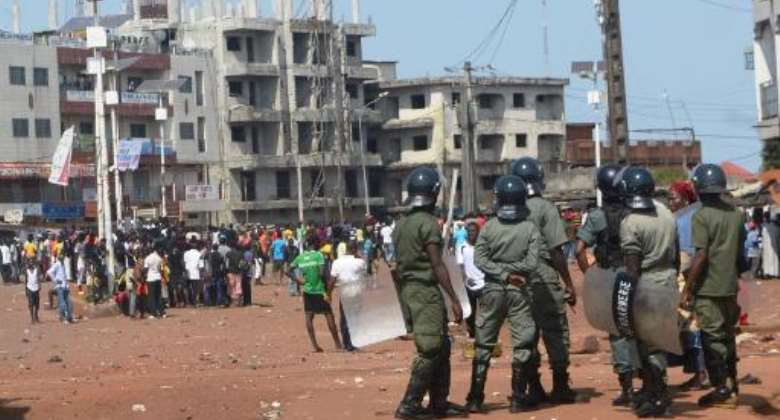 Demonstrators face riot police in Conakry on November 16, 2013.  By Cellou Binani AFPFile