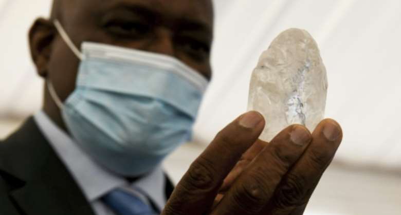 Botswana President Mokgweetsi Masisi holds up the diamond, said to be the third largest of its kind.  By Monirul Bhuiyan AFP
