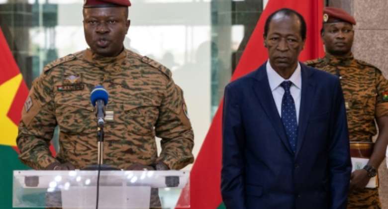 Burkina Faso's new strongman, Lieutenant-Colonel Paul-Henri Sandaogo Damiba L, speaks beside former president Blaise Compaore R.  By OLYMPIA DE MAISMONT AFP
