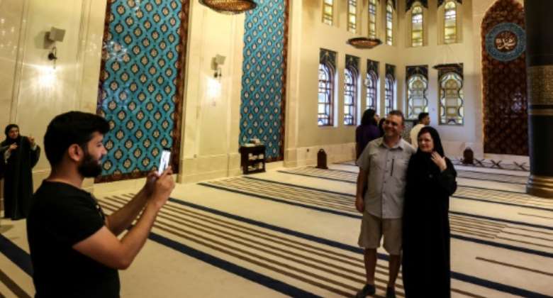 Canadian couple Dorinel and Clara Popa pose for a picture inside Doha's Blue Mosque.  By MAHMUD HAMS AFP