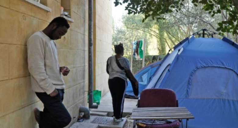 Daniel Ejube (L) and Grace Enjei (R), two Cameroonian nationals, had been stuck in Cyprus's buffer zone since May, living in a tent behind a building.  By Roy ISSA (AFP)