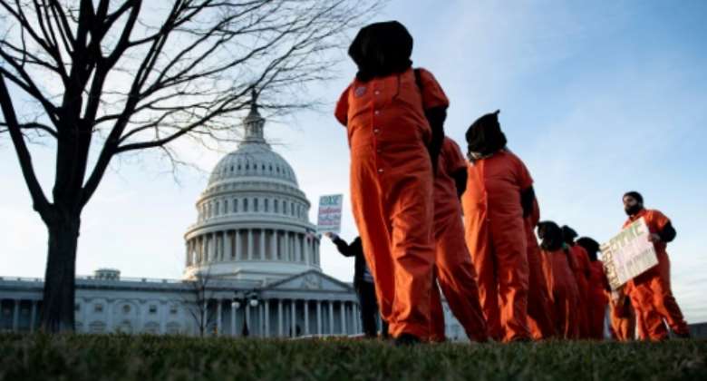 Demonstrators dressed in Guantanamo Bay prisoner uniforms march past Capitol Hill in Washington, DC, on January 9, 2020.  By Brendan Smialowski AFPFile