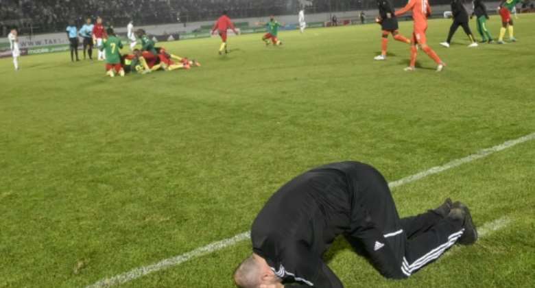 Down and out: Algeria's coach Djamel Belmadi reacts after Cameroon's late winner.  By - AFPFile