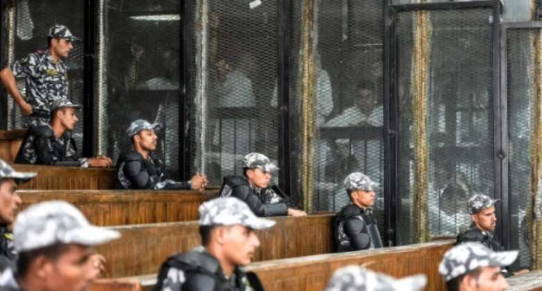 Egyptian security peronnel line the public gallery as Muslim Brotherhood members appear in the caged dock at a trial hearing in July 2018.  By Khaled DESOUKI AFPFile