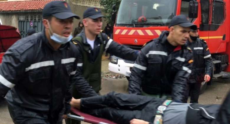 Emergency services carry a man on a stretcher outside the workshop  in  Tangiers.  By - AFP