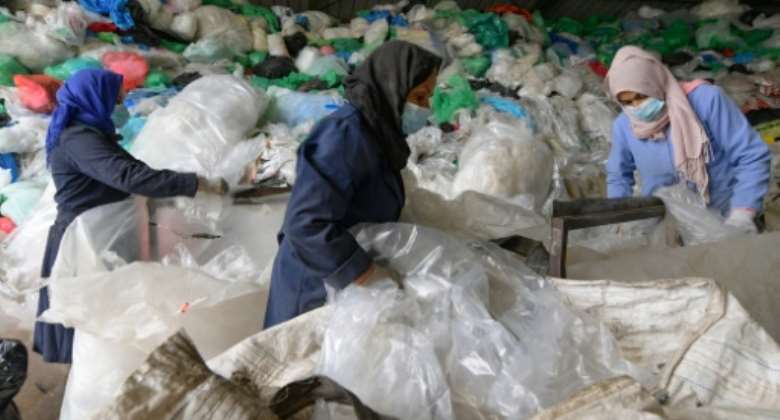 Employees sort through piles of plastic waste at African Recycling, one of the few recycling companies in Tunisia.  By FETHI BELAID (AFP)