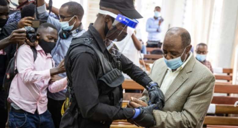 Hotel Rwanda hero Paul Rusesabagina, right, is handcuffed in a Kigali court.  By STRINGER AFPFile
