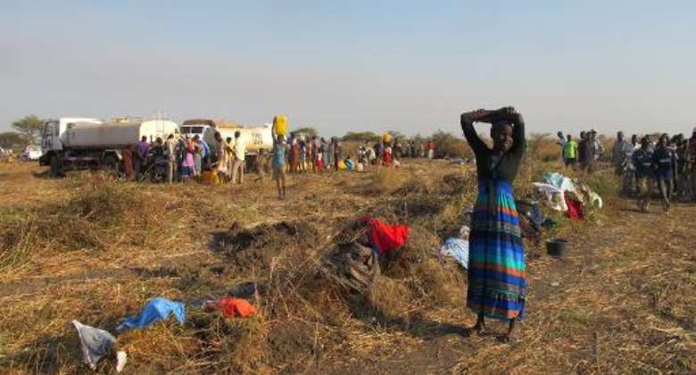 In this photo released by the United Nations Mission in South Sudan (UNMISS) on December 25, 2013 people fill jerrycans with water from UN trucks in Bentiu on December 24, 2013.  By Anna Adhikari (UNMISS/AFP)