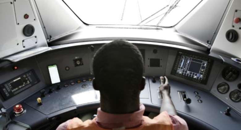 Let the train take the strain: Driver Momar Diop Sidibe in one of Dakar's brand-new commuter locomotives.  By SEYLLOU AFP