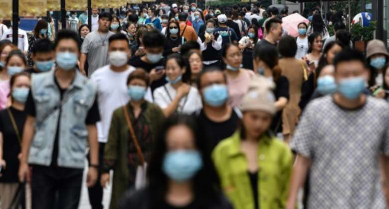 Many people in Wuhan, where the coronavirus first emerged, are still wearing masks despite there being no new cases since May.  By Hector RETAMAL AFP