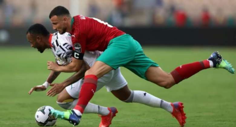 Morocco captain and defender Romain Saiss R and Ghana forward Jordan Ayew fight for the ball.  By Kenzo Tribouillard AFP