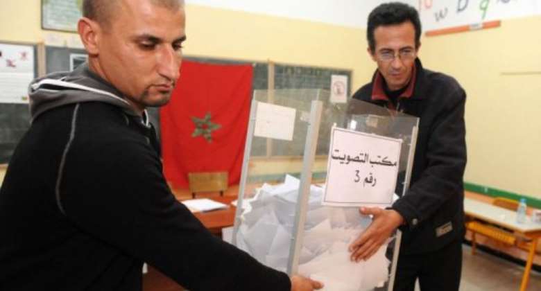 Electoral agents carry the ballot box prior vote counting.  By Abdelhak Senna (AFP)