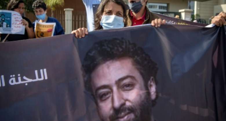 Omar Radi's mother holds a banner picture of her son at a protest in Casablanca in this file picture from September 22, 2020.  By FADEL SENNA AFPFile