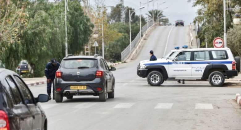 Police cars block access to a road near a courthouse in the Algerian city of Blida where an appeal hearing is underway in the trial of the brother of former president Abdelaziz Bouteflika and three other key figures.  By RYAD KRAMDI AFP