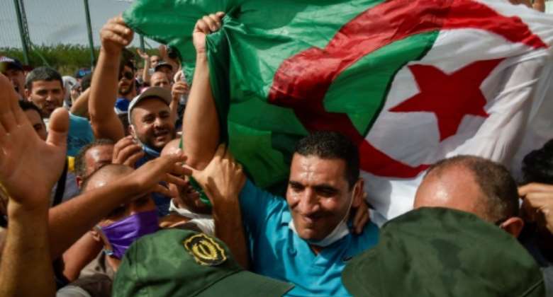 Prominent opposition figure Karim Tabbou is greeted upon his release from Kolea Prison on July 2, 2020, near the city of Tipasa, Algeria.  By RYAD KRAMDI AFPFile