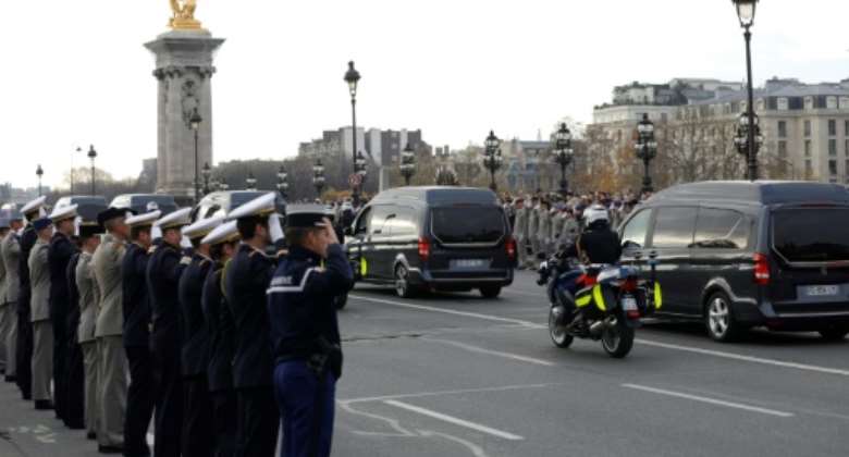 Soldiers saluted as the funeral convoy carrying 13 French soldiers killed in Mali crossed the Alexandre III bridge in Paris on Monday, ahead of a commemoration at the Invalides military hospital..  By GEOFFROY VAN DER HASSELT AFP