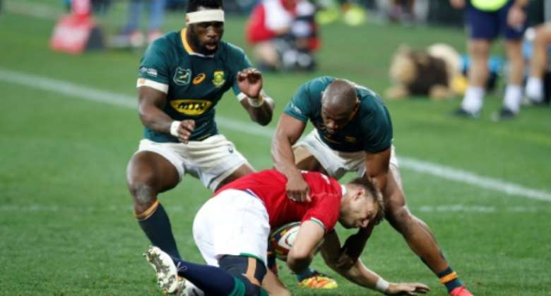 South Africa skipper and flanker Siya Kolisi L and winger Makazole Mapimpi R try to dispossess British and Irish Lions scrum-half Conor Murray during the second Test in Cape Town last weekend.  By PHILL MAGAKOE AFP