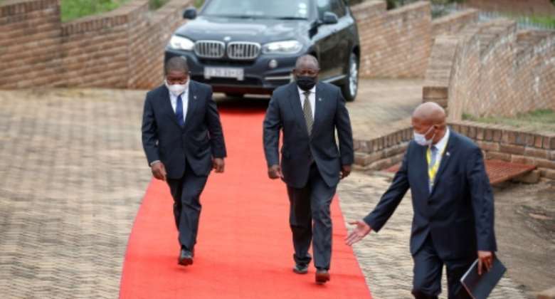 South African President Cyril Ramaphosa C and Mozambican President Filipe Nyusi L arrive at the 35th commemoration of former Mozambican President Samora Machel's death in Mbuzini on October 19, 2021.  By Phill Magakoe AFP